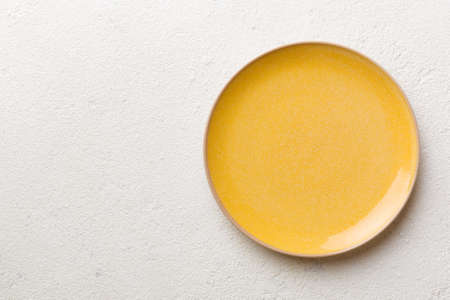 Top view of empty orange plate on cement background. Empty space for your design.の写真素材