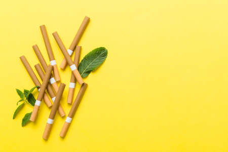 Menthol cigarettes and fresh mint leaves on colored background, Many cigarettes stacked together top view flat lay.の写真素材