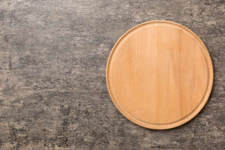 Top view of wooden cutting board on cement background. Empty space for your design.の写真素材