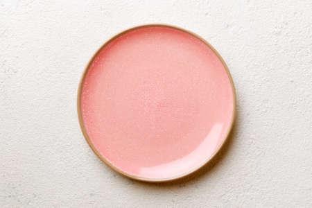 Top view of empty pink plate on cement background. Empty space for your design.
