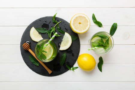 Caipirinha, Mojito cocktail, vodka or soda drink with lime, mint and straw on table background. Refreshing beverage with mint and lime in glass top view flat lay.の写真素材