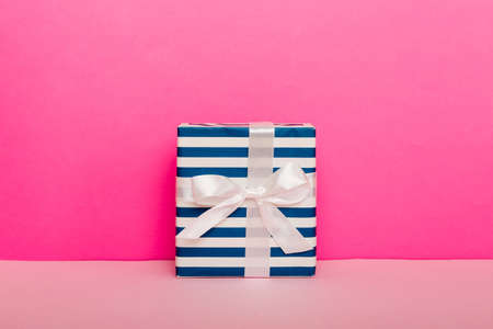 holiday handmade present tied pink ribbon bow top view with copy space. Flat lay holiday background....