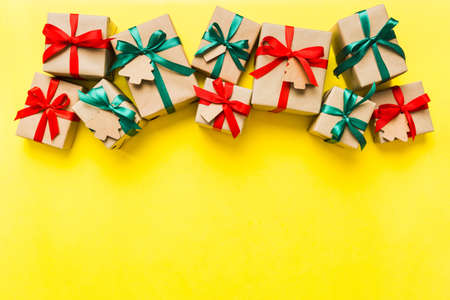 wrapped christmas or other holiday handmade present in paper with colored ribbon. Present box, decoration of gift on colorfull table, top view with copy space.の写真素材