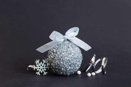 Christmas ball on colored background. decoration bauble with ribbon bow with copy space.