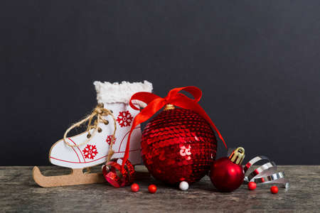 Christmas ball with skates on colored background. decoration bauble with ribbon bow with copy space.の写真素材
