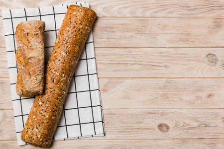 fresh crunchy french baguette on colored table. Top view Bakery products.
