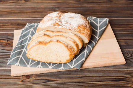 Assortment of freshly sliced baked bread with napkin on rustic table top view. Healthy unleavened...