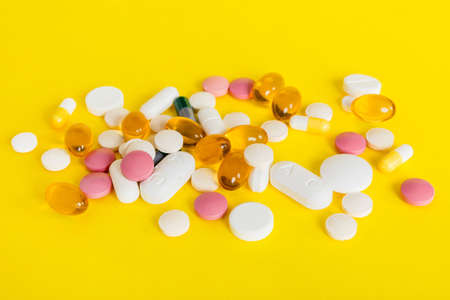 Many different colorful medications and pills perspective view. Set of many pills on colored...