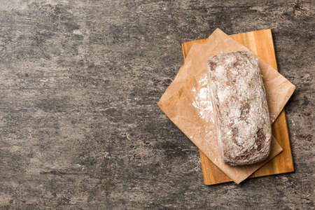 Freshly baked bread on cutting board against white wooden background. top view bread with copy space.の写真素材