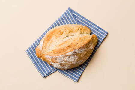 Freshly baked delicious french bread with napkin on rustic table top view. Healthy white bread loaf.