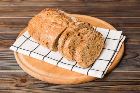 Assortment of freshly sliced baked bread with napkin on rustic table top view. Healthy unleavened...