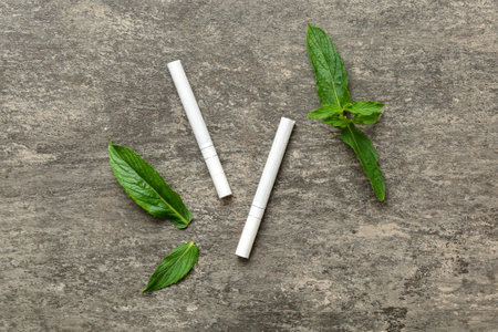 Menthol cigarettes and fresh mint leaves on colored background, Many cigarettes stacked together top view flat lay.の写真素材