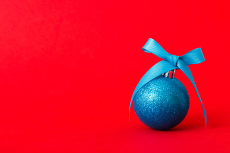 Christmas ball on colored background. decoration bauble with ribbon bow with copy space.の写真素材