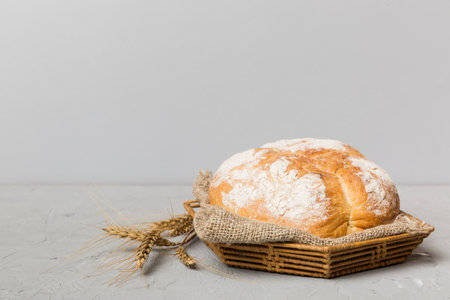 Freshly baked bread on basket against natural background. Perspective view bread copy space.