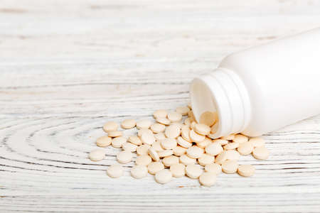 different drugs and health supplement pills poured from a medicine bottle health care and medical...