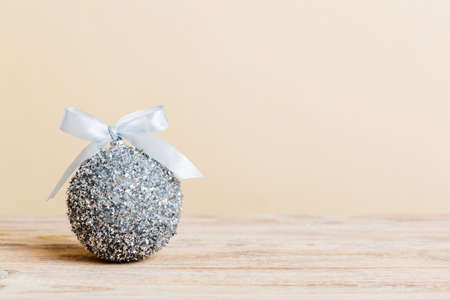 Christmas ball on colored background. decoration bauble with ribbon bow with copy space.