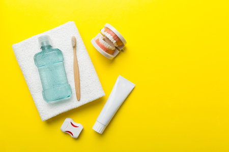Mouthwash and other oral hygiene products on colored table top view with copy space. flat lay....