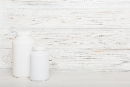 supplement pills with medicine bottle health care and medical top view. vitamin tablets. Top view mockup bottle for pills and vitamins with green leaves, natural organic bio supplement, copy space.の写真素材