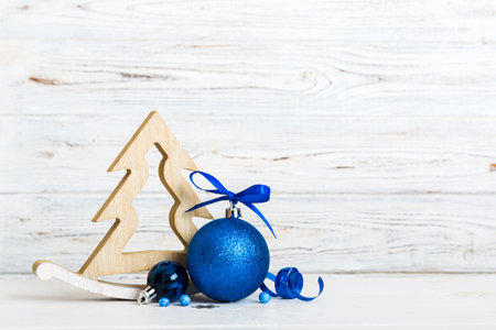 Christmas ball with decorative wooden tree on colored background. decoration bauble with ribbon bow with copy space.の写真素材
