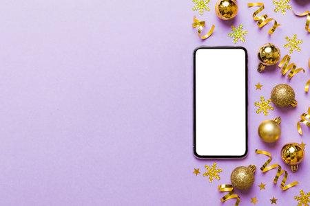 Christmas online shopping from home phone with blank white display top view. smart mobile with copy space on colored background with Christmas decorations balls,. Winter holidays sales background.の写真素材