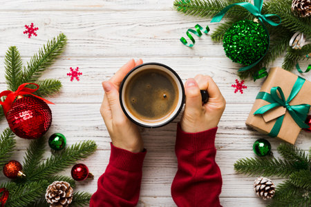 Woman holding cup of coffee. Woman hands holding a mug with hot coffee. Winter and Christmas time concept.の写真素材