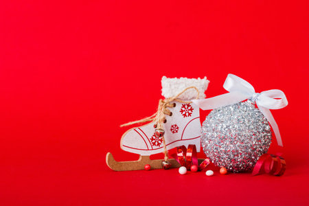 Christmas ball with skates on colored background. decoration bauble with ribbon bow with copy space.の写真素材