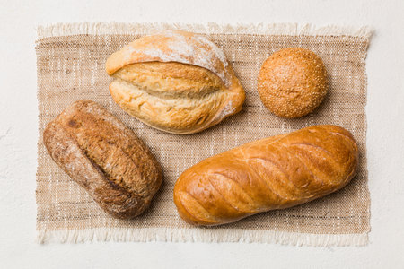 Assortment of freshly baked bread with napkin on rustic table top view. Healthy unleavened bread. French bread.の写真素材