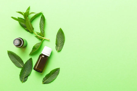 Natural Mint Essential Oil in a Glass Bottle. organic cosmetics with herbal extracts of mint on...