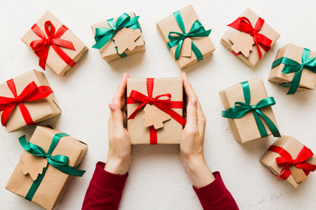 Woman hands holding gift box, preparing surprise for holiday, top view, Christmas and New Year...