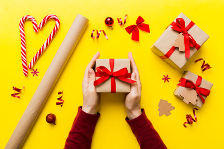 Woman hands holding gift box, preparing surprise for holiday, top view, Christmas and New Year concept.の写真素材
