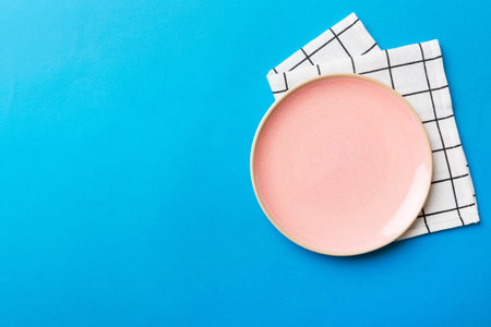 Top view on colored background empty round pink plate on tablecloth for food. Empty dish on napkin with space for your design.の写真素材
