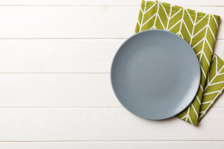 Top view on colored background empty round gray plate on tablecloth for food. Empty dish on napkin with space for your design.の写真素材