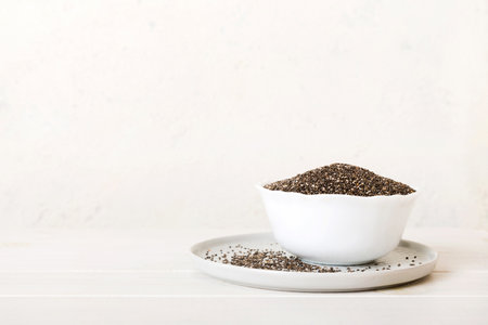 Chia seeds in bowl on colored background. Healthy Salvia hispanica in small bowl. Healthy superfood.の写真素材