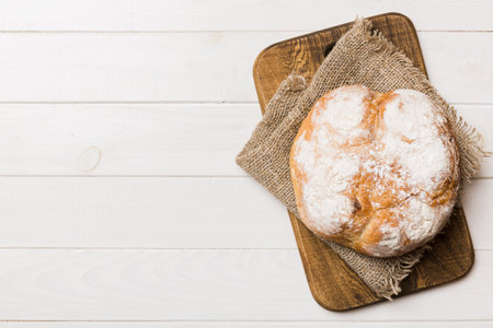 Freshly baked bread on cutting board against white wooden background. top view bread with copy...