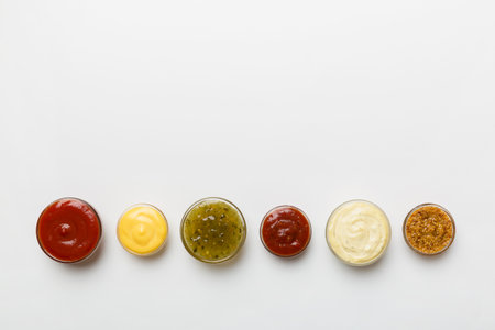 Different types of sauces in bowls on a colored Board . top view. various sauces copy space.