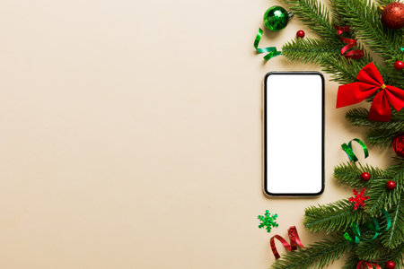 christmas mockup with space for text. christmas advertising app template. hand holding phone with empty screen on table background. Happy New Year and Xmas Flat lay.の写真素材