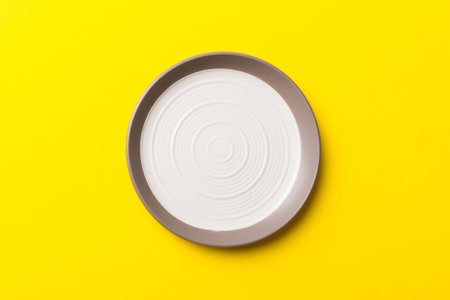 Top view of isolated of colored background empty round white plate for food. Empty dish with space for your design.の写真素材