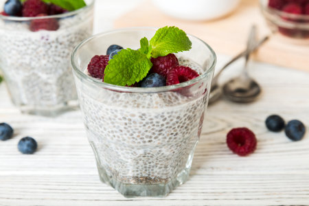 Healthy breakfast or morning with chia seeds vanilla pudding raspberry and blueberry berries on table background, vegetarian food, diet and health concept. Chia pudding with raspberry and blueberry.の写真素材