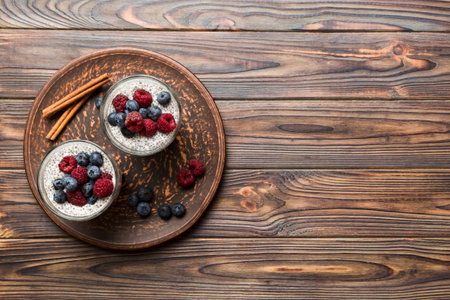Healthy breakfast or morning with chia seeds vanilla pudding raspberry and blueberry berries on table background, vegetarian food, diet and health concept. Chia pudding with raspberry and blueberry.の写真素材