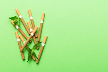 Menthol cigarettes and fresh mint leaves on colored background, Many cigarettes stacked together top view flat lay.の写真素材