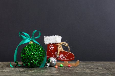 Christmas ball with skates on colored background. decoration bauble with ribbon bow with copy space.の写真素材