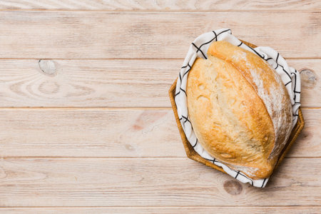 Freshly baked bread on cutting board against white wooden background. top view bread with copy...