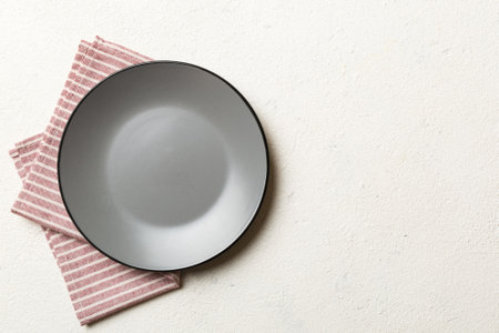 Top view on colored background empty round gray plate on tablecloth for food. Empty dish on napkin with space for your design.の写真素材