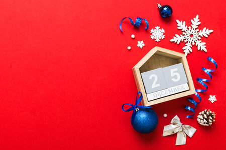 Christmas calendar 25 december. Christmas gift, fir branches, pine cones. Flat lay, top view. New Year decorations on a colored background.の写真素材