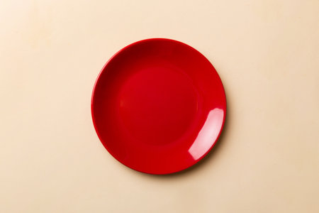 Top view of isolated of colored background empty round red plate for food. Empty dish with space for...