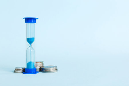 Deadline and time is money concept with hourglass and US coins currency. sand clock time saving...