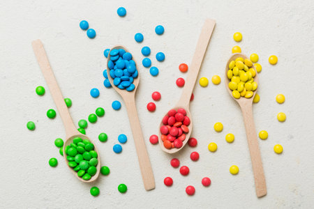 delicious colorful sweet candies on spoon on colored background . Confectionery decor top view with copy space.の写真素材