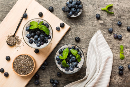 Healthy breakfast or morning with chia seeds vanilla pudding and blueberry berries on table background, vegetarian food, diet and health concept. Chia pudding with coconut milk and blueberry.の写真素材