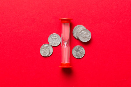 Deadline and time is money concept with hourglass and US coins currency. sand clock time saving...