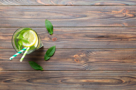 Caipirinha, Mojito cocktail, vodka or soda drink with lime, mint and straw on table background. Refreshing beverage with mint and lime in glass top view flat lay.の写真素材
